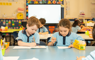 A photo of two students reading books in the library at St Charles' School Waverley